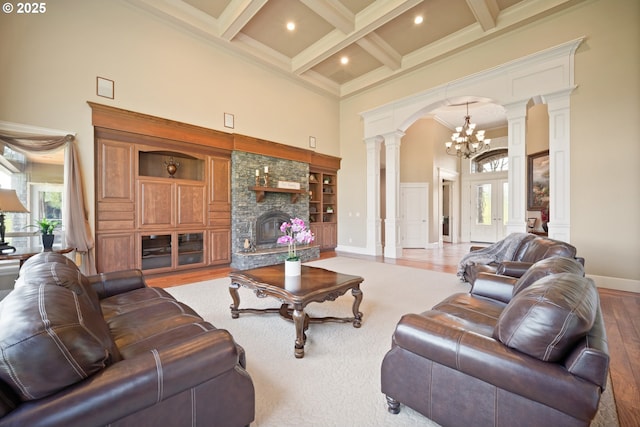 living area featuring beamed ceiling, decorative columns, a healthy amount of sunlight, and a towering ceiling