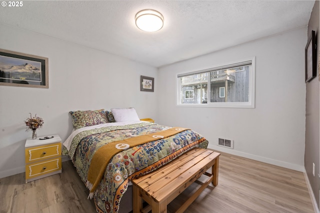 35208 Orchard Ln, Astoria, OR 97103 - bedroom featuring light wood-style flooring, baseboards, and a textured ceiling