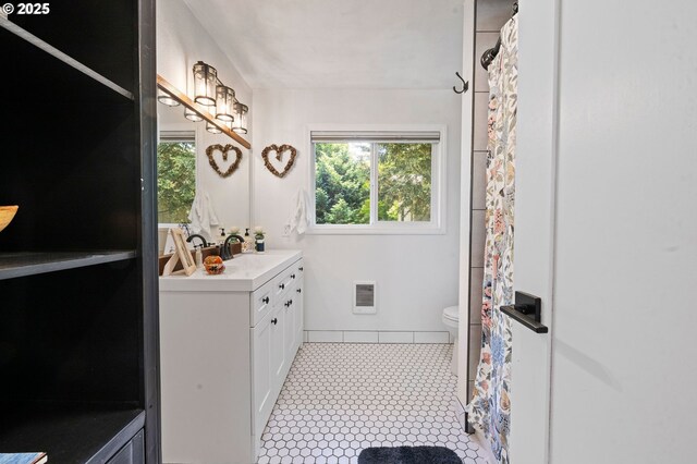 35208 Orchard Ln, Astoria, OR 97103 - bathroom with vanity, toilet, heating unit, and tile patterned floors
