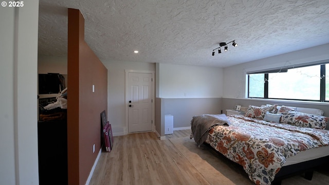 35208 Orchard Ln, Astoria, OR 97103 - bedroom with light wood finished floors, a textured ceiling, and baseboards