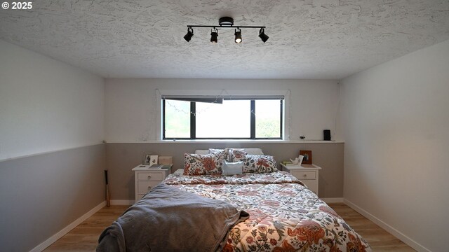 35208 Orchard Ln, Astoria, OR 97103 - bedroom featuring light wood finished floors, baseboards, and a textured ceiling