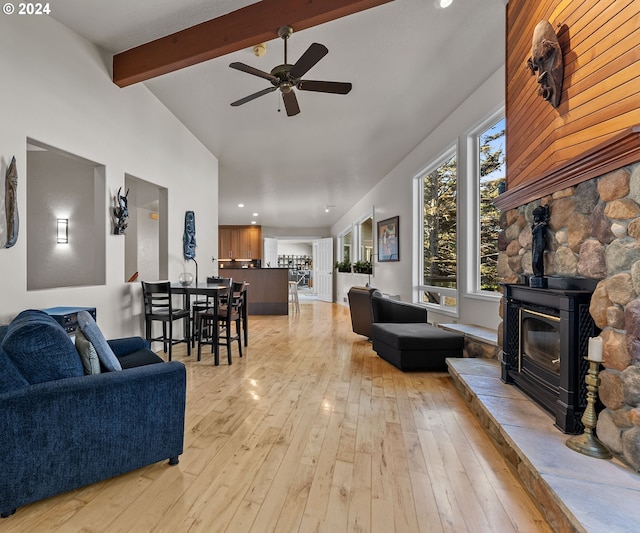 living room featuring lofted ceiling with beams, ceiling fan, and light wood-type flooring