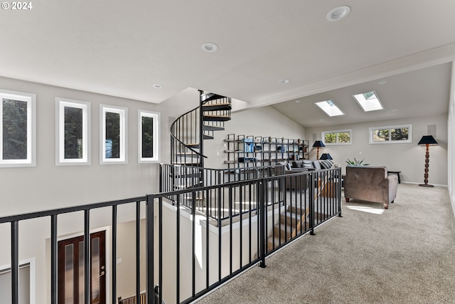 hall featuring lofted ceiling with skylight and carpet