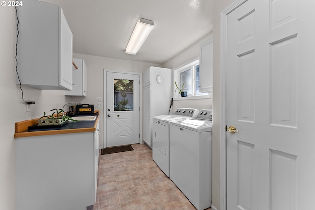 laundry room with cabinets, washing machine and dryer, and sink