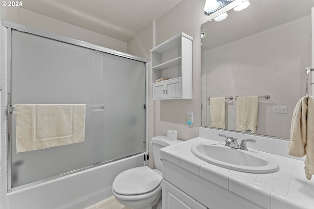 full bathroom featuring vanity, shower / bath combination with glass door, and toilet