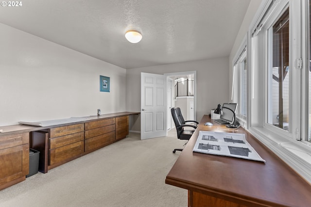 carpeted home office featuring a textured ceiling