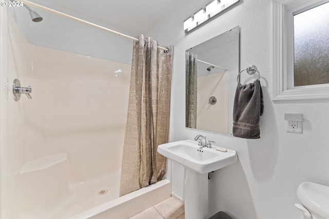 bathroom featuring sink, tile patterned floors, toilet, and walk in shower