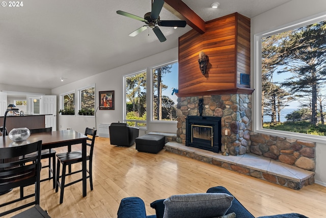 living room with beam ceiling, light hardwood / wood-style flooring, and a wealth of natural light