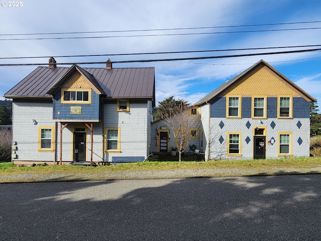 view of front of house featuring a standing seam roof, a chimney, and metal roof