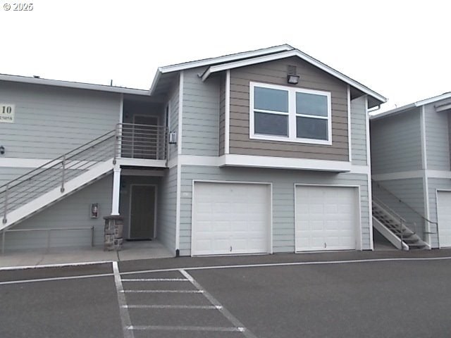 view of front of home featuring an attached garage and stairway