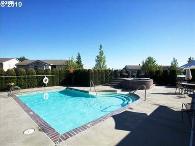 pool featuring a jacuzzi and a patio