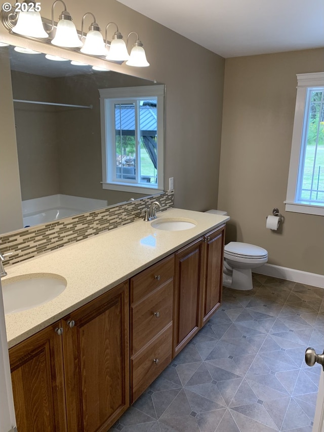 24945 Oak Ln, Elmira, OR 97437 - bathroom with double vanity, toilet, baseboards, and bathing tub / shower combination