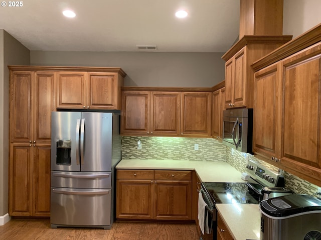 24945 Oak Ln, Elmira, OR 97437 - kitchen featuring appliances with stainless steel finishes, brown cabinets, backsplash, and recessed lighting
