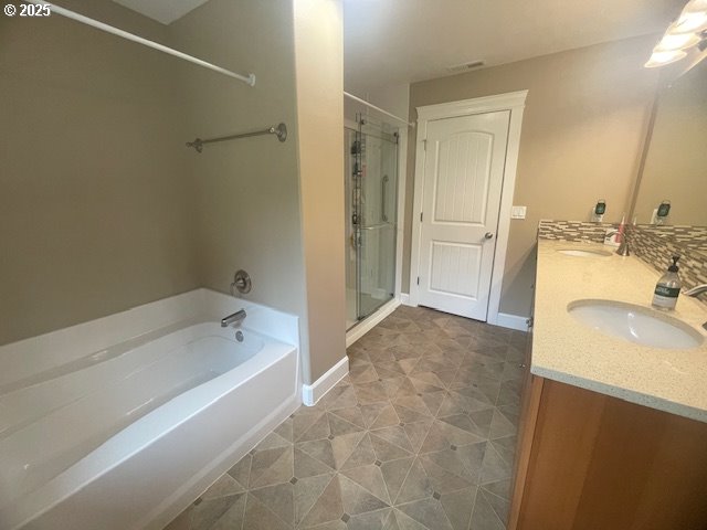 24945 Oak Ln, Elmira, OR 97437 - full bathroom with double vanity, a garden tub, a stall shower, and baseboards