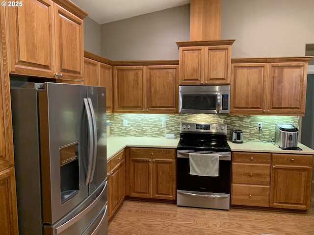 24945 Oak Ln, Elmira, OR 97437 - kitchen featuring stainless steel appliances, light countertops, tasteful backsplash, light wood-style flooring, and vaulted ceiling