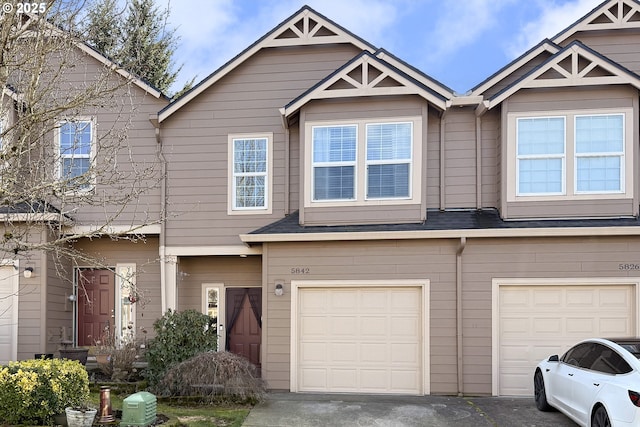 townhome / multi-family property featuring driveway and an attached garage