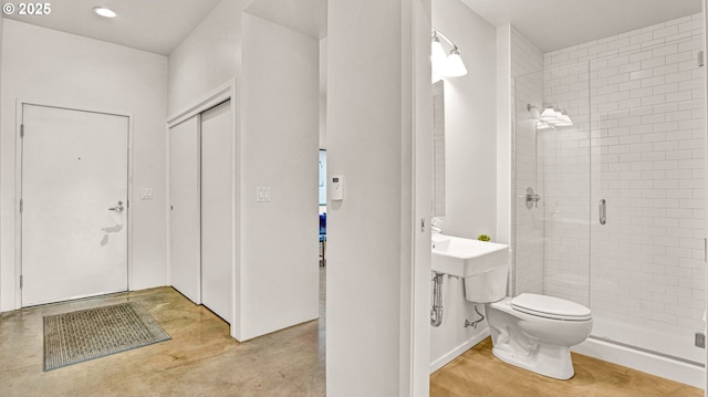 bathroom featuring toilet and an enclosed shower