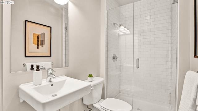 bathroom featuring sink, an enclosed shower, and toilet