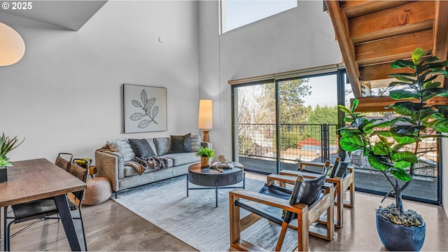 living room with a towering ceiling and concrete flooring