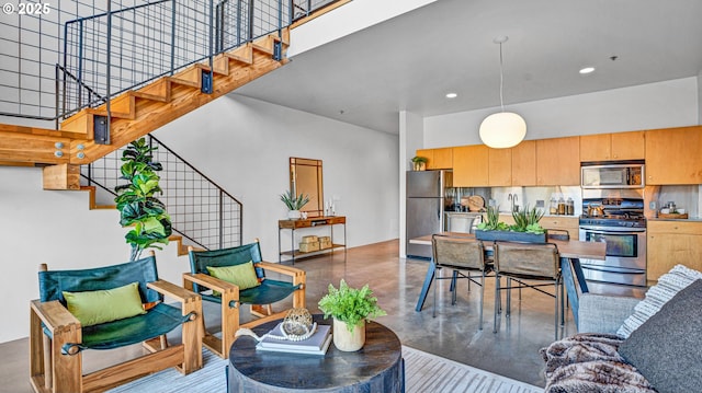 living room with a towering ceiling and concrete floors