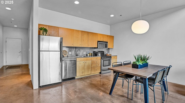 kitchen featuring tasteful backsplash, sink, stainless steel appliances, and hanging light fixtures