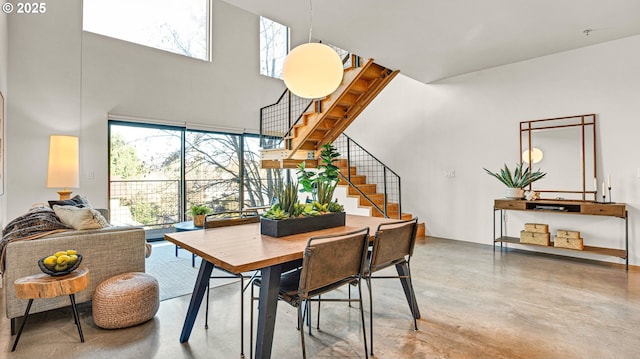 dining space with concrete flooring and a high ceiling