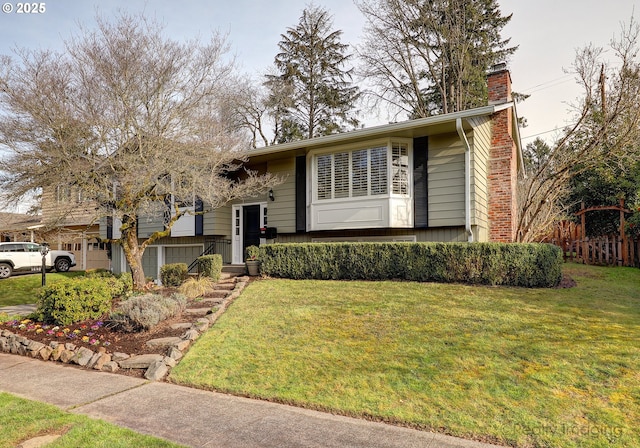 split foyer home featuring a garage and a front yard