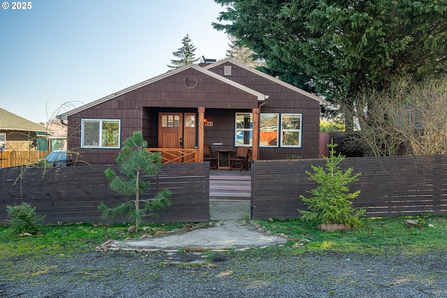 view of front of property featuring a fenced front yard and covered porch