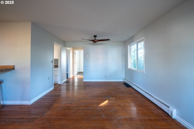 spare room featuring a ceiling fan, baseboards, dark wood-style flooring, and baseboard heating