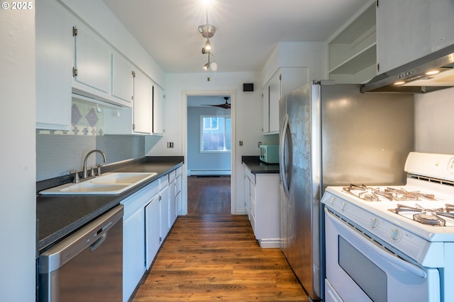 kitchen with white appliances, dark wood-style floors, a sink, decorative backsplash, and a baseboard heating unit