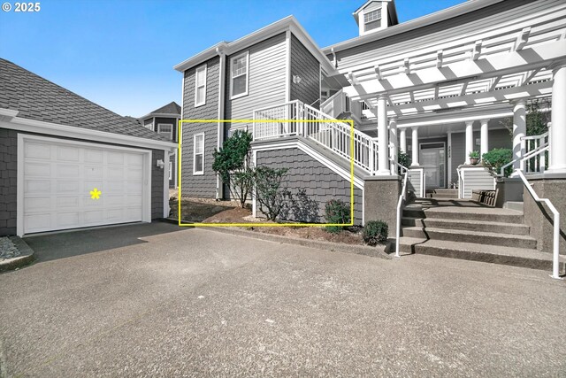 view of property exterior with a pergola, aphalt driveway, and a garage