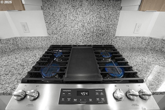 details featuring cooktop and decorative backsplash