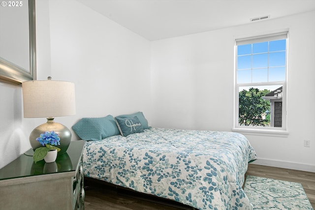 bedroom featuring visible vents, wood finished floors, and multiple windows