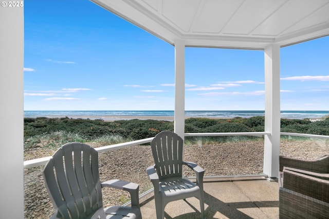 sunroom featuring a water view