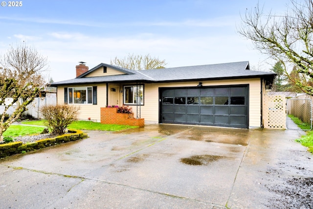 view of front of house featuring a garage, concrete driveway, a chimney, and fence