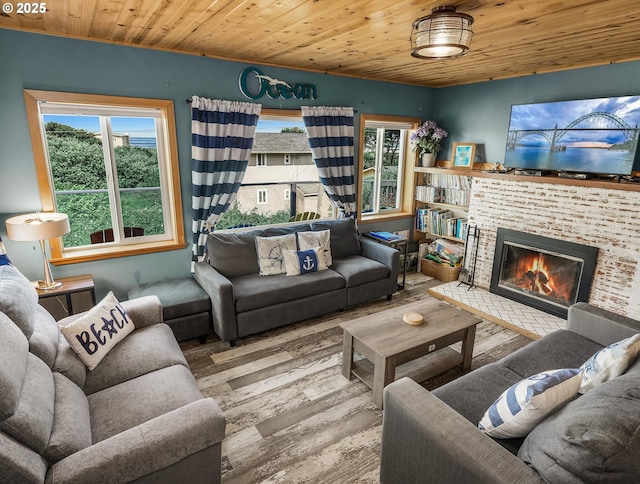 5353 SW Neal Ave, Waldport, OR 97394 - living room featuring wood finished floors, plenty of natural light, wood ceiling, and a brick fireplace