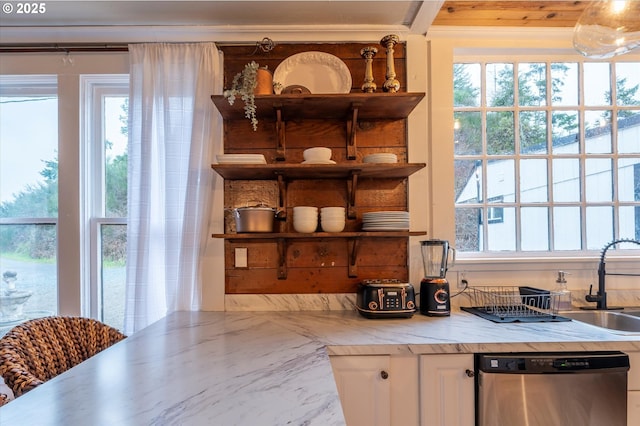 kitchen with light countertops, stainless steel dishwasher, white cabinetry, and a healthy amount of sunlight