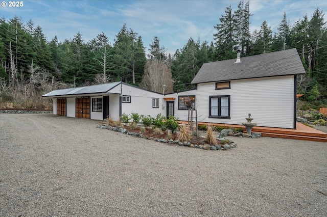 view of front of home featuring a garage and gravel driveway