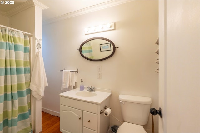 bathroom with toilet, ornamental molding, wood finished floors, and vanity