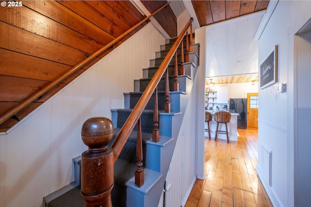 stairs featuring wooden ceiling, visible vents, vaulted ceiling, and wood-type flooring