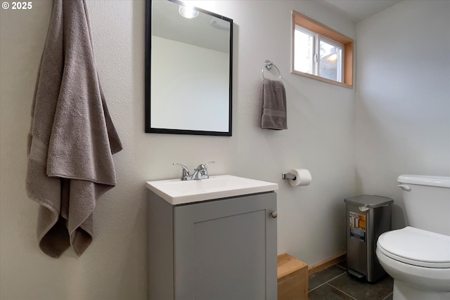 half bath with toilet, tile patterned flooring, and vanity