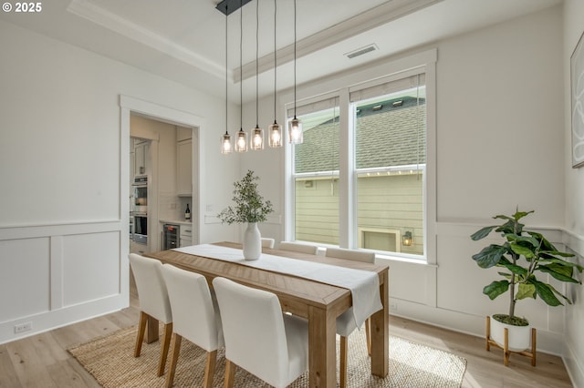 11723 NW Sadie St, Portland, OR 97229 - dining space with a decorative wall, light wood-style floors, a wainscoted wall, beverage cooler, and a raised ceiling