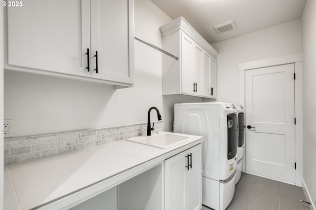 11723 NW Sadie St, Portland, OR 97229 - laundry room featuring washer and clothes dryer, cabinet space, and light tile patterned floors