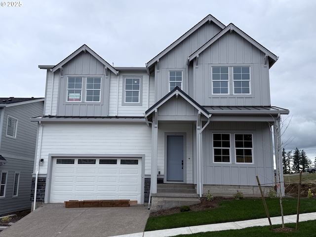 view of front of property featuring metal roof, a garage, driveway, board and batten siding, and a standing seam roof