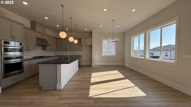 11699 SW 178th Dr, Beaverton, OR 97007 - kitchen featuring stainless steel double oven, under cabinet range hood, dark countertops, recessed lighting, and tasteful backsplash