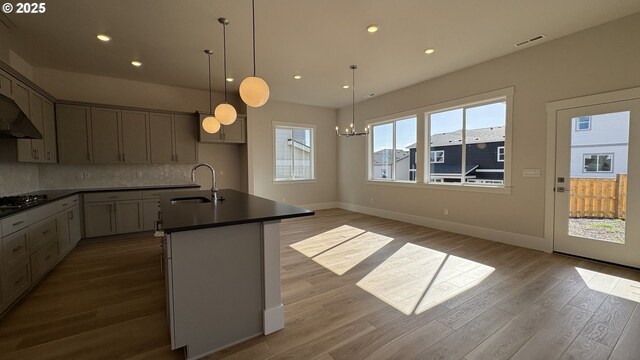 11699 SW 178th Dr, Beaverton, OR 97007 - kitchen featuring stainless steel appliances, under cabinet range hood, dark countertops, hanging light fixtures, and decorative backsplash