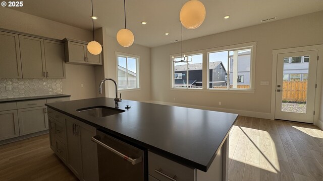 11699 SW 178th Dr, Beaverton, OR 97007 - kitchen with under cabinet range hood, dark countertops, light wood-style floors, stainless steel appliances, and gray cabinets