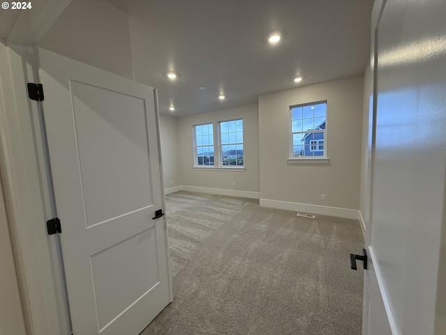 spare room featuring recessed lighting, carpet flooring, visible vents, and baseboards