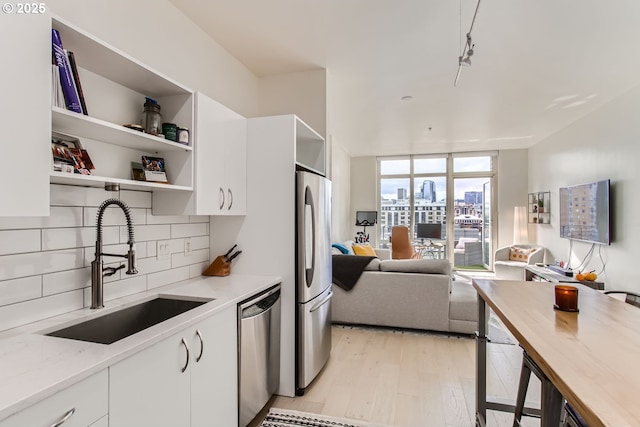 1255 NW 9th Ave Unit 806, Portland, OR 97209 - kitchen with decorative backsplash, appliances with stainless steel finishes, open shelves, light wood-type flooring, and a sink