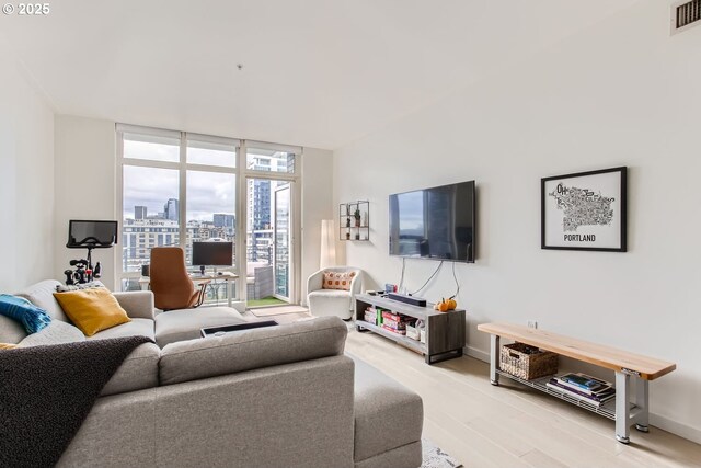 1255 NW 9th Ave Unit 806, Portland, OR 97209 - living room with light wood-type flooring, baseboards, visible vents, and a wall of windows